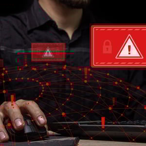 Photo of a person using a computer mouse and keyboard, overlayed with images of a web, locks, and exclamation points.