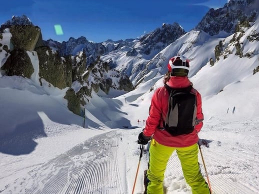 Firefly skier looking down a steep mountain chute