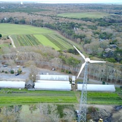 Photo of a wind turbine above a rural landscape