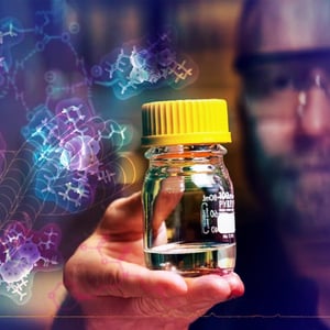 Photograph of researcher holding solvent with an overlay of molecules and spectra