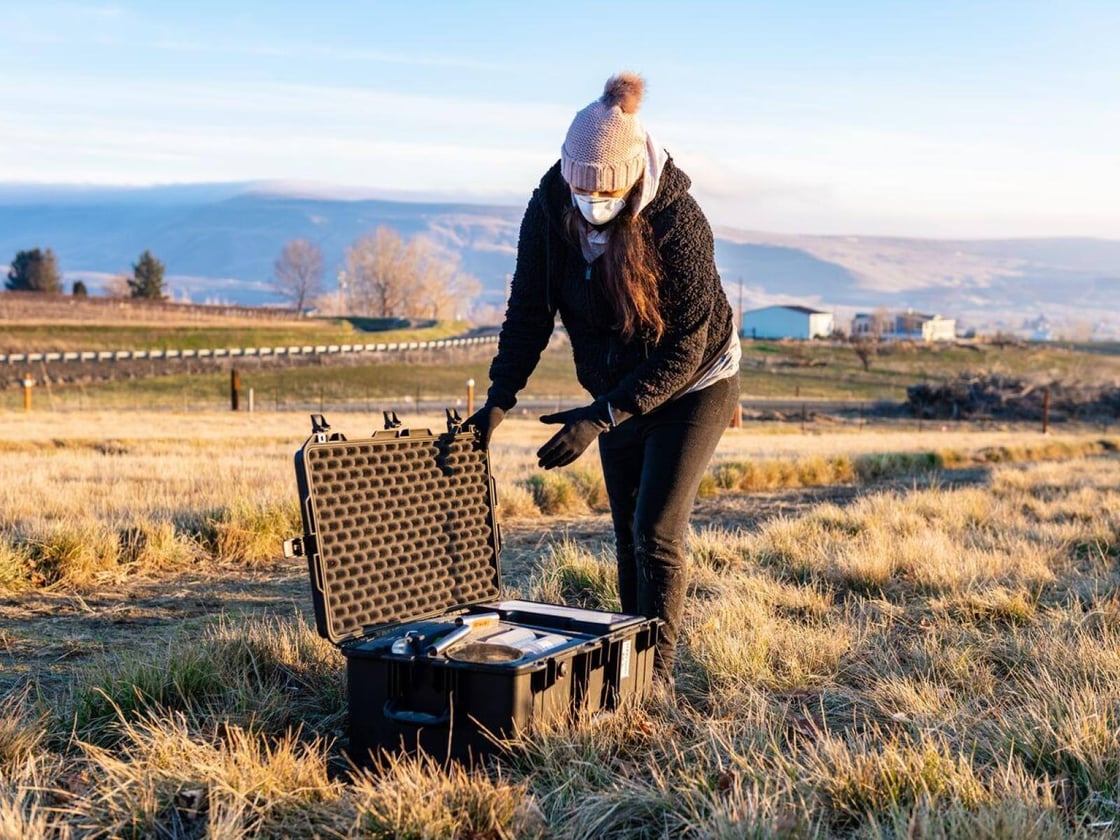 Photograph shows Emily Graham collecting soil as part of her work studying microbes in the soil.