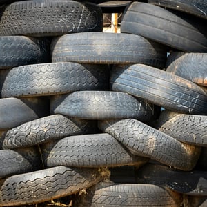 Photograph shows stack of old tires.