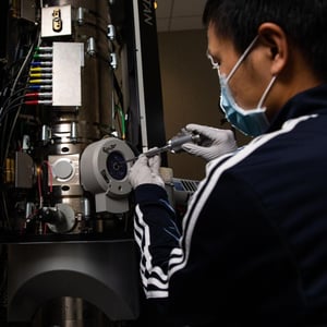 Photo of a person inserting a battery sample into transmission electron microscope.