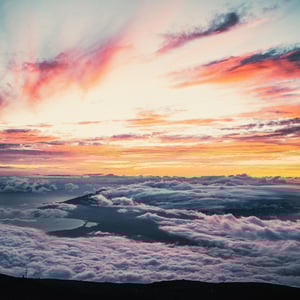 Sunlight illuminates sprawling clouds, casting glowing hues of pink and orange that are, in part, determined by aerosol particles. 